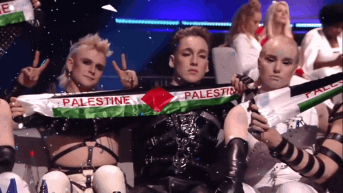 a group of people holding a palestine scarf