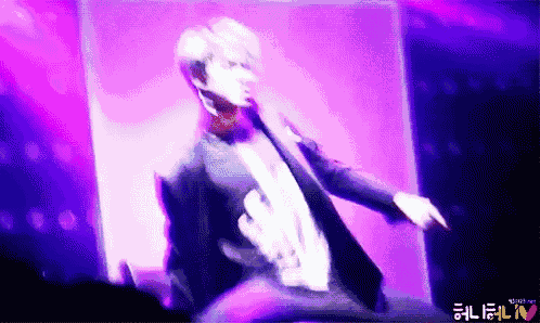 a man in a tuxedo is dancing in front of a purple background that says ' ntv ' on the bottom