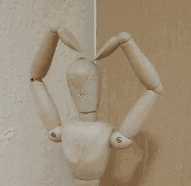 a wooden mannequin is making a heart shape with its arms