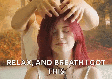 a woman with red hair is getting a head massage from a man .