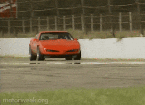 a red car is driving on a race track and the website motorweek.org is visible in the corner