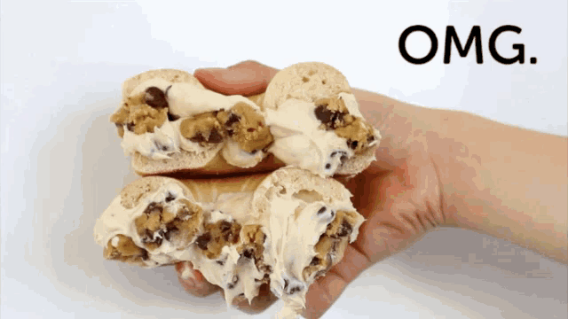 a person is holding a bagel with the word omg written on the bottom