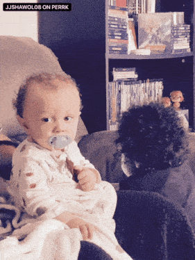 a baby is sitting on a couch with a pacifier in his mouth and the caption jjshawolo8 on perrk above it