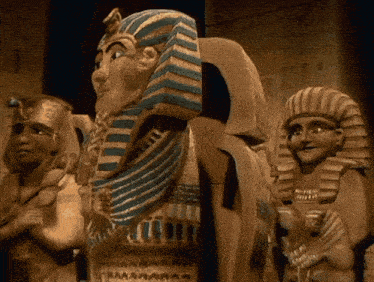 a statue of a man with a blue and white striped hat stands next to two other statues