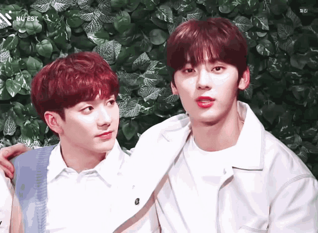 two boys are standing next to each other with the word nuest on the bottom