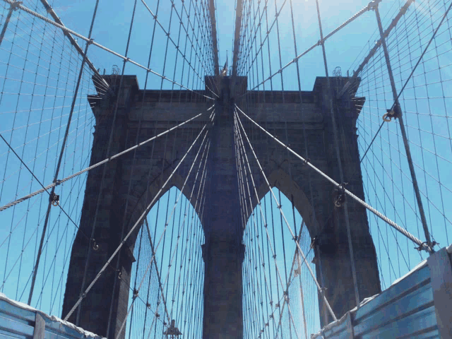 looking up at the brooklyn bridge on a clear day