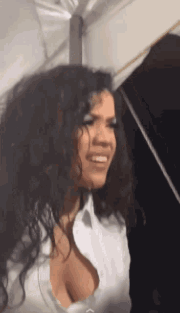 a woman with curly hair is wearing a white shirt