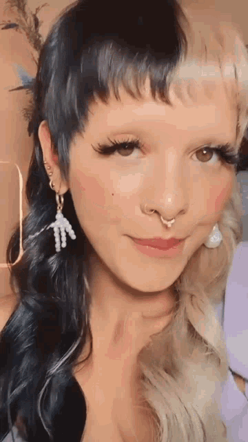 a close up of a woman wearing a nose ring and earrings