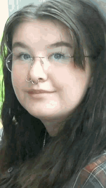 a woman wearing glasses and a nose ring