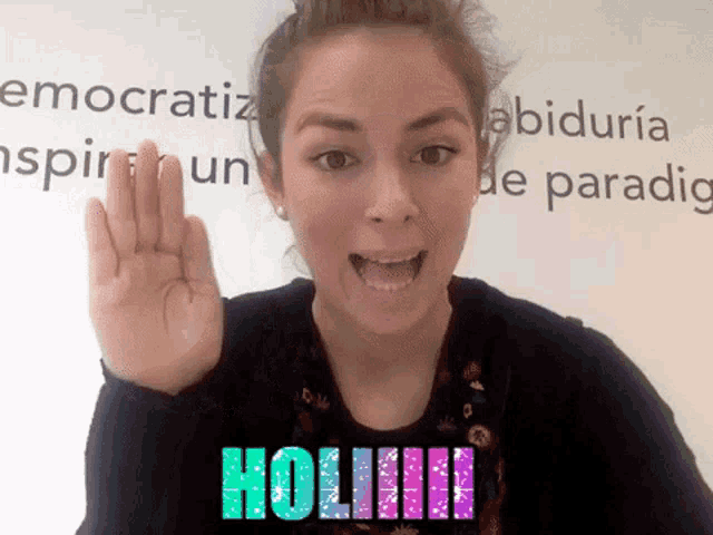 a woman giving a high five in front of a wall that says ' hoiiii '