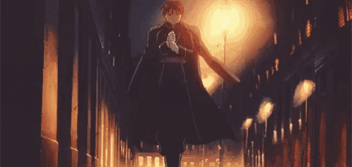 a man in a black cape is standing in a dark alleyway with a street light in the background .