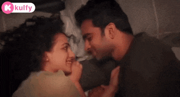 a man and a woman are kissing on a bed .