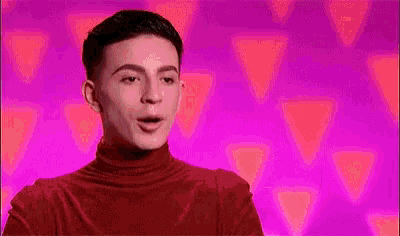 a young man in a red turtleneck sweater is making a funny face .