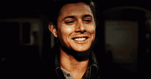 a close up of a man smiling with his mouth open .