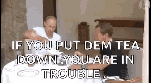 two men are sitting at a table with a caption that says `` if you put dem tea down , you are in trouble '' .