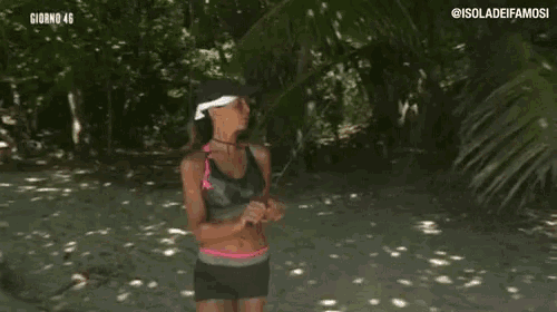a woman is standing on a beach holding a stick in her hand .