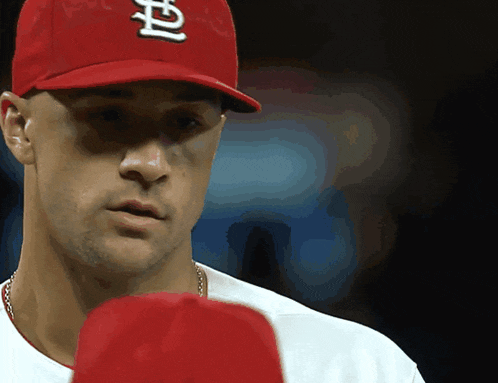 a close up of a man wearing a red hat with the letter p on it