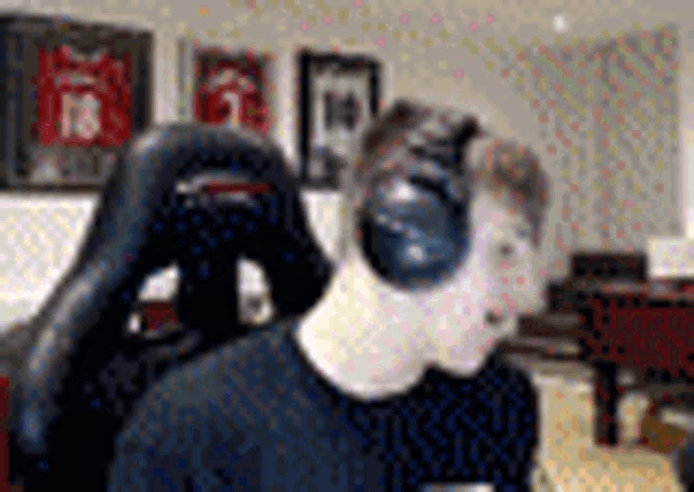 a young man wearing headphones is sitting in a gaming chair .