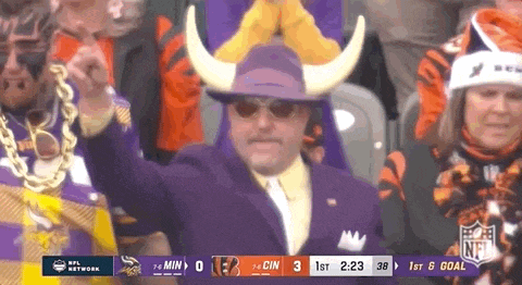 a man wearing a purple suit and a purple hat with horns stands in front of a scoreboard that says nfl network