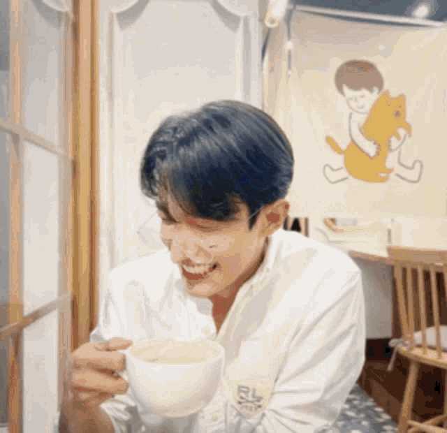 a man is holding a cup of coffee and smiling