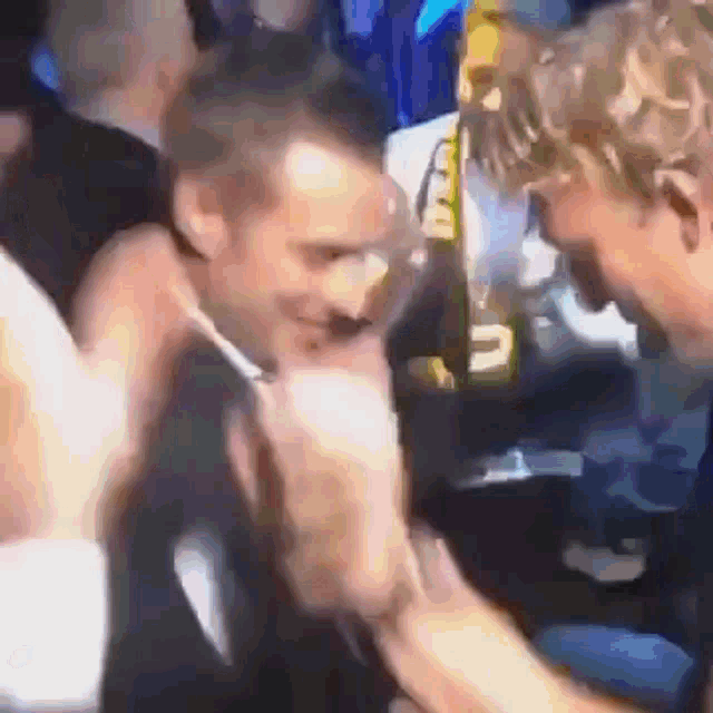 a blurry picture of a man talking to another man in a crowded room