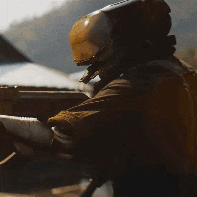 a man in a helmet is holding a gun in his hand .