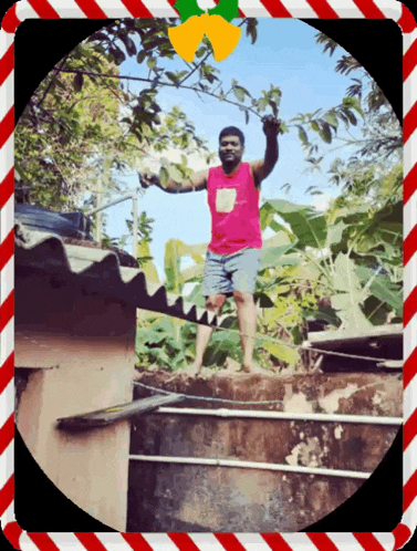 a man in a pink tank top and blue shorts is standing on the roof of a building