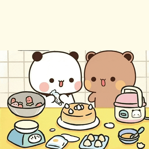 a couple of bears sitting at a table with a cake