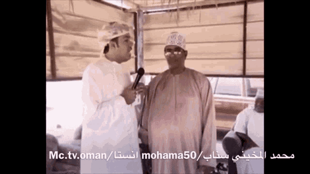 a man talking into a microphone with the words mc.tv.oman/mohama50 on the bottom of the screen