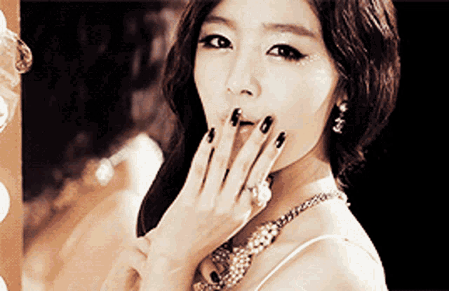 a woman with black nails and a gold necklace