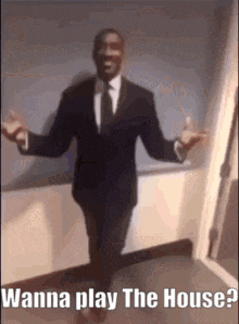 a man in a suit and tie is dancing in a hallway with the words `` wanna play the house ? ''