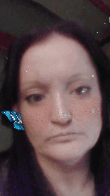 a close up of a woman 's face with a butterfly on her nose
