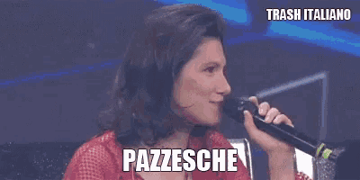 a woman is singing into a microphone with the words pazzesche written on the bottom .