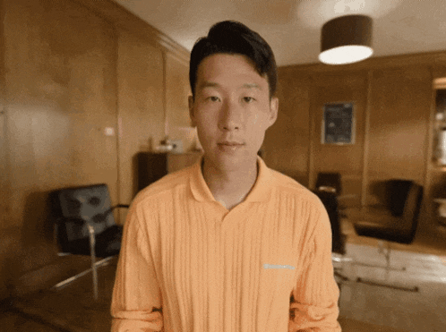 a young man in an orange shirt with the word champion on the back