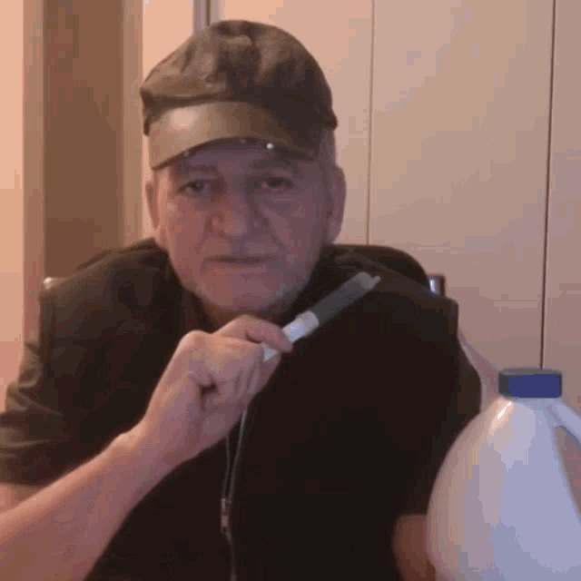 a man in a hat is holding a syringe next to a white bottle