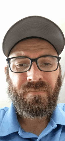 a man with glasses and a beard wearing a hat