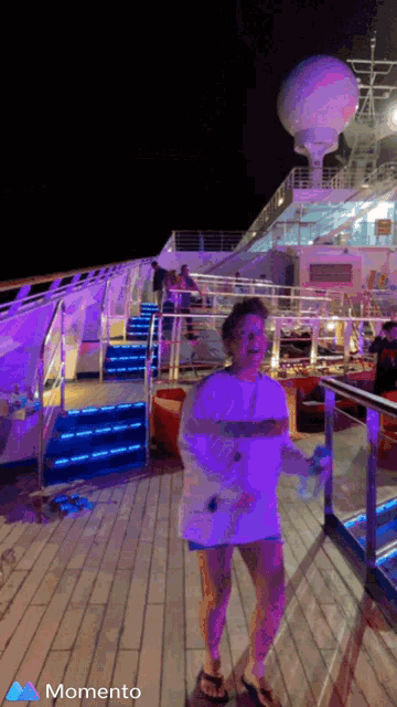 a woman standing on a deck with the word momento on the bottom right