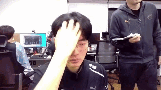 a man in a puma jacket holds his head