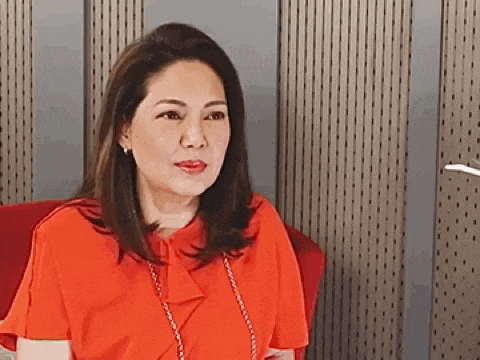 a woman in a red shirt is sitting on a red chair .