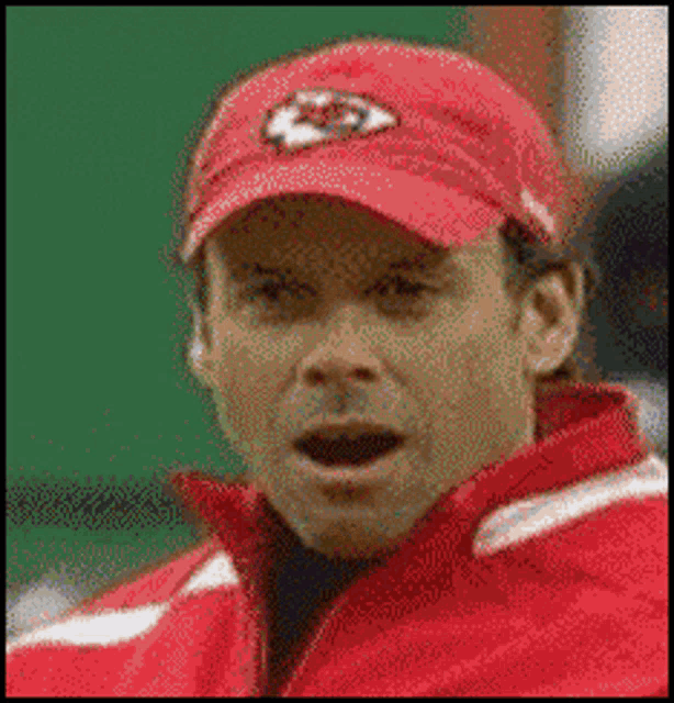 a man wearing a red hat with a kc logo on it
