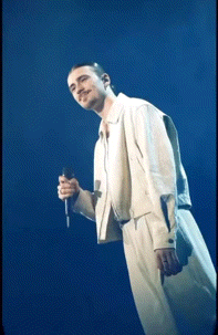 a man is singing into a microphone on a stage