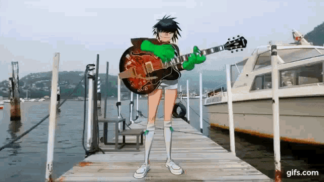 a person standing on a dock holding a guitar