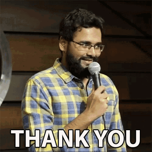 a man in a plaid shirt is holding a microphone and says thank you