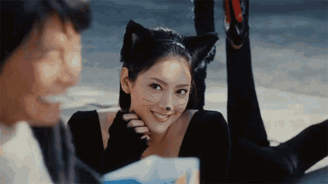 a woman in a cat costume is laying on the ground