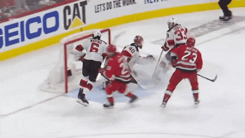 a hockey game is being played in front of an ad for geico cat
