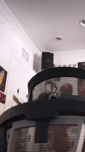 a bose speaker is hanging from the ceiling next to a chair