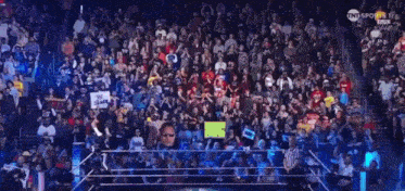 a large crowd of people are watching a wrestling match on tnt sports 1