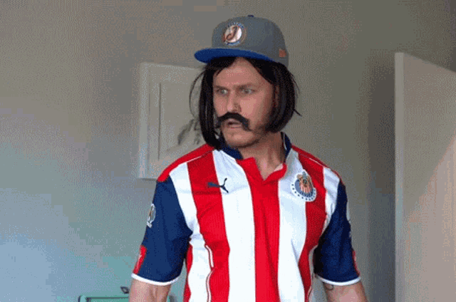 a man wearing a red white and blue striped shirt and a baseball cap