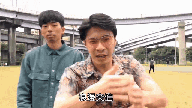 a man wearing sunglasses stands next to another man with chinese writing on his face