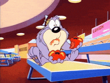 a cartoon character is sitting on a table eating tomatoes in a cafeteria .